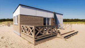 Nowoczesny domek modułowy z tarasem, idealny jako domek mobilny lub dom mobilny. Stylowa architektura i funkcjonalne rozwiązania sprawiają, że jest to doskonały wybór dla osób szukających komfortowych domów modułowych. - Gołdap